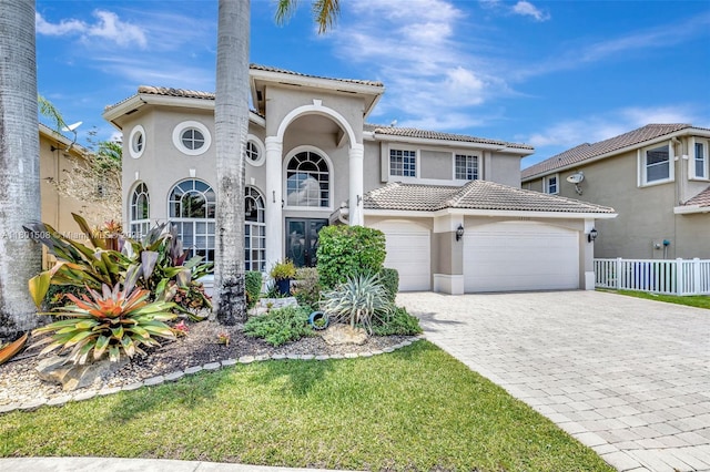 12339 NW 25th St, Coral Springs, FL 33065 - mediterranean / spanish house featuring stucco siding, a tile roof, decorative driveway, a garage, and fence