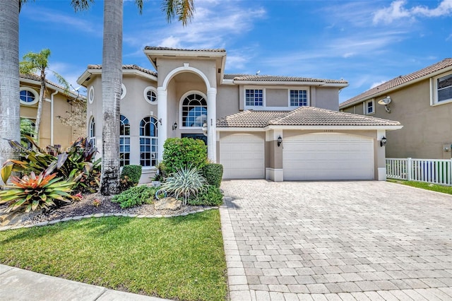 12339 NW 25th St, Coral Springs, FL 33065 - mediterranean / spanish-style home featuring a tiled roof, decorative driveway, stucco siding, a garage, and fence