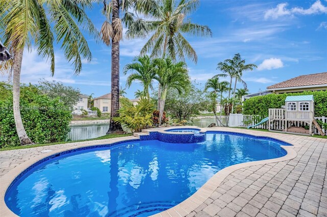 12339 NW 25th St, Coral Springs, FL 33065 - view of swimming pool featuring a fenced backyard, a pool with connected hot tub, and a water view