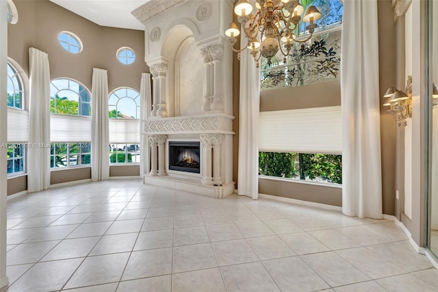 12339 NW 25th St, Coral Springs, FL 33065 - unfurnished living room featuring a chandelier, tile patterned floors, a glass covered fireplace, and a towering ceiling
