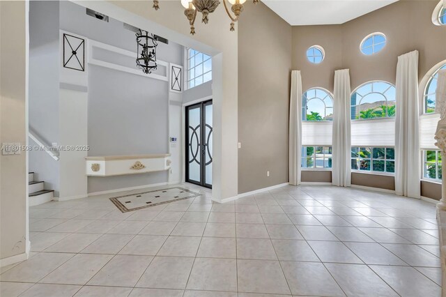 12339 NW 25th St, Coral Springs, FL 33065 - entryway with a high ceiling, plenty of natural light, tile patterned flooring, and baseboards