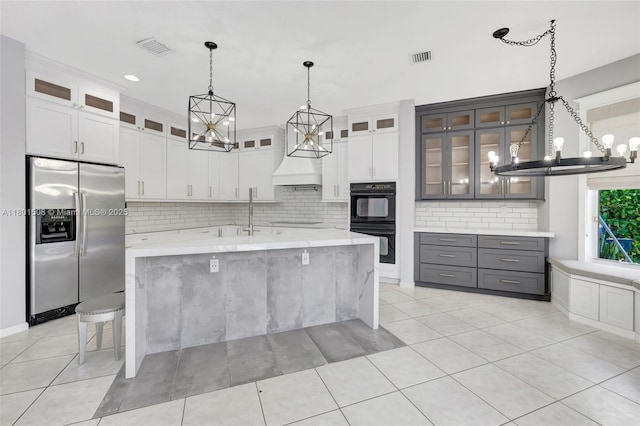 12339 NW 25th St, Coral Springs, FL 33065 - kitchen featuring black appliances, a chandelier, a sink, backsplash, and a center island with sink