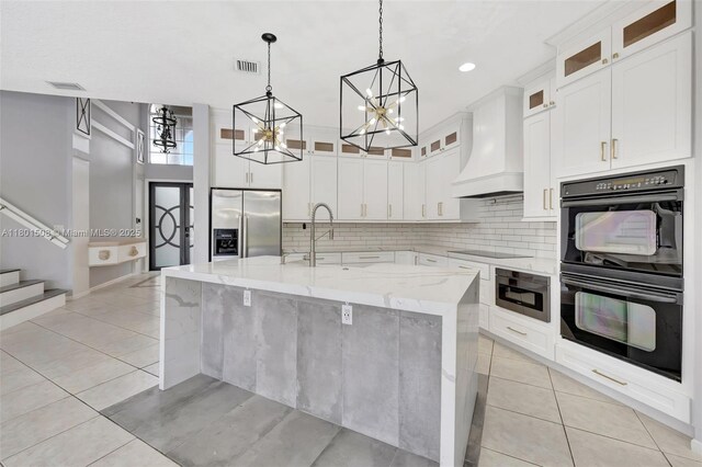 12339 NW 25th St, Coral Springs, FL 33065 - kitchen with black appliances, custom exhaust hood, a chandelier, backsplash, and light tile patterned floors