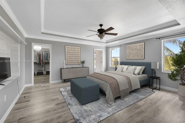 12339 NW 25th St, Coral Springs, FL 33065 - bedroom featuring a tray ceiling, multiple windows, baseboards, a walk in closet, and crown molding