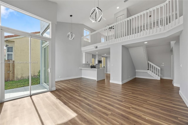 3835 Lombardy St, Hollywood, FL 33021 - unfurnished living room featuring baseboards, wood finished floors, stairs, and high vaulted ceiling