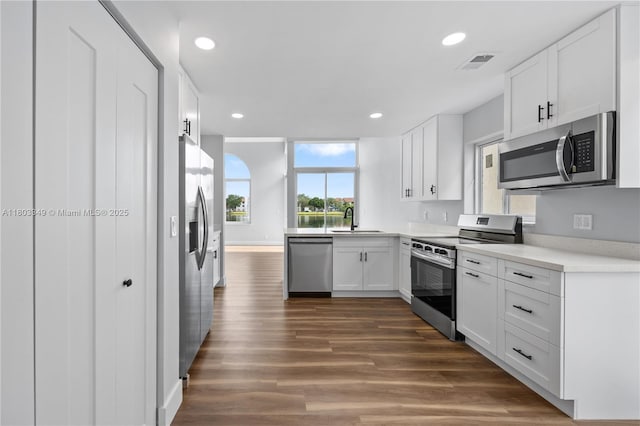 3835 Lombardy St, Hollywood, FL 33021 - kitchen with appliances with stainless steel finishes, a sink, white cabinetry, dark wood-style flooring, and recessed lighting