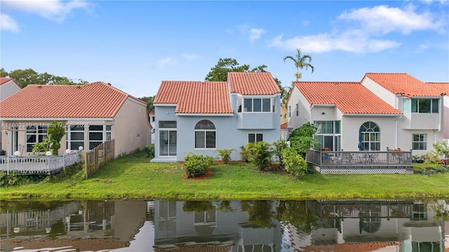 3835 Lombardy St, Hollywood, FL 33021 - rear view of property featuring a tile roof, stucco siding, a water view, and a yard