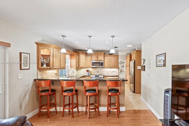 9750 SW 143rd Dr, Miami, FL 33176 - kitchen featuring stainless steel appliances, a peninsula, backsplash, and a kitchen bar