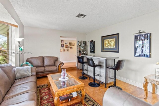 9750 SW 143rd Dr, Miami, FL 33176 - living room with a textured ceiling, wood finished floors, baseboards, and a dry bar