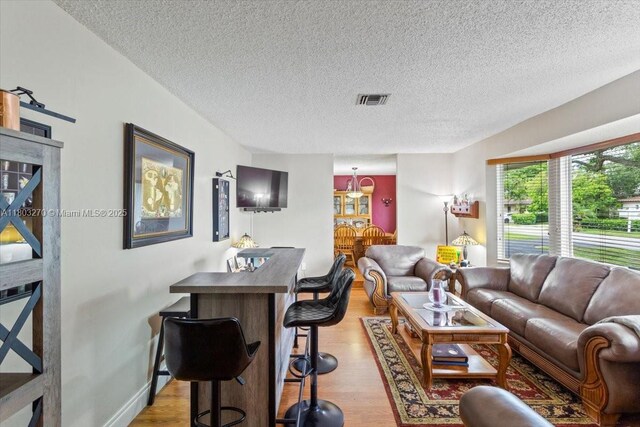 9750 SW 143rd Dr, Miami, FL 33176 - living room featuring light wood-style floors, a textured ceiling, and baseboards