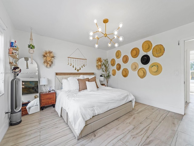 7165 W 13th Ave, Hialeah, FL 33014 - bedroom with a chandelier, baseboards, and light wood-style flooring