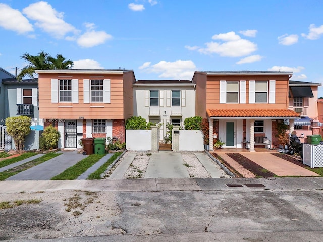 7165 W 13th Ave, Hialeah, FL 33014 - townhome / multi-family property with a gate, covered porch, concrete driveway, and brick siding