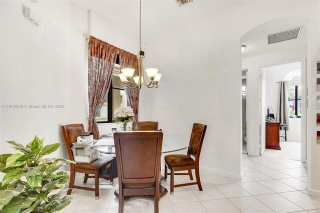 2901 NW 126th Ave Unit 2-415, Sunrise, FL 33323 - dining area with a chandelier, arched walkways, baseboards, and light tile patterned floors