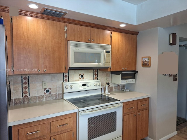 1101 SW 75th Ter, Plantation, FL 33317 - kitchen featuring white appliances, brown cabinetry, decorative backsplash, and recessed lighting