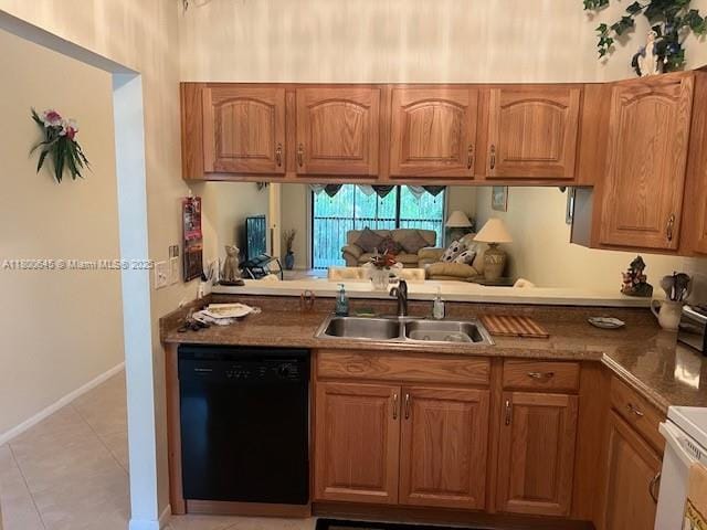 kitchen featuring black dishwasher, a sink, brown cabinetry, a peninsula, and light tile patterned floors