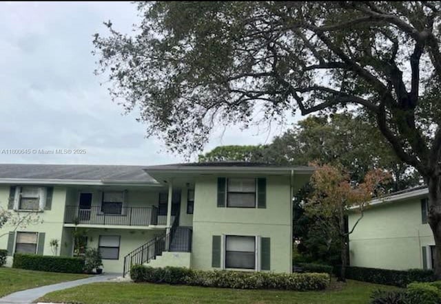 1301 Sabal Ridge Cir Unit G, Palm Beach Gardens, FL 33418 - view of front of house featuring stucco siding, a front yard, and stairs