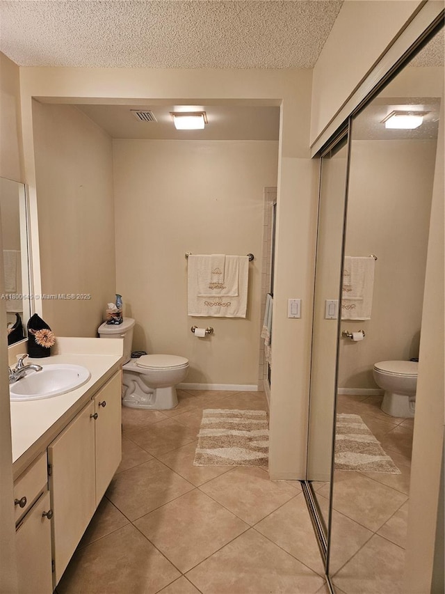 1301 Sabal Ridge Cir Unit G, Palm Beach Gardens, FL 33418 - bathroom featuring toilet, vanity, tile patterned flooring, a textured ceiling, and a shower