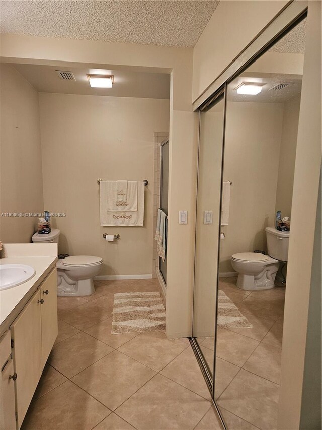 1301 Sabal Ridge Cir Unit G, Palm Beach Gardens, FL 33418 - full bath with toilet, a textured ceiling, a stall shower, tile patterned flooring, and vanity