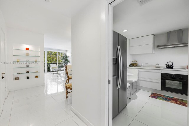 1 Harbour Way Unit 305, Bal Harbour, FL 33154 - kitchen featuring black appliances, wall chimney exhaust hood, modern cabinets, and light countertops
