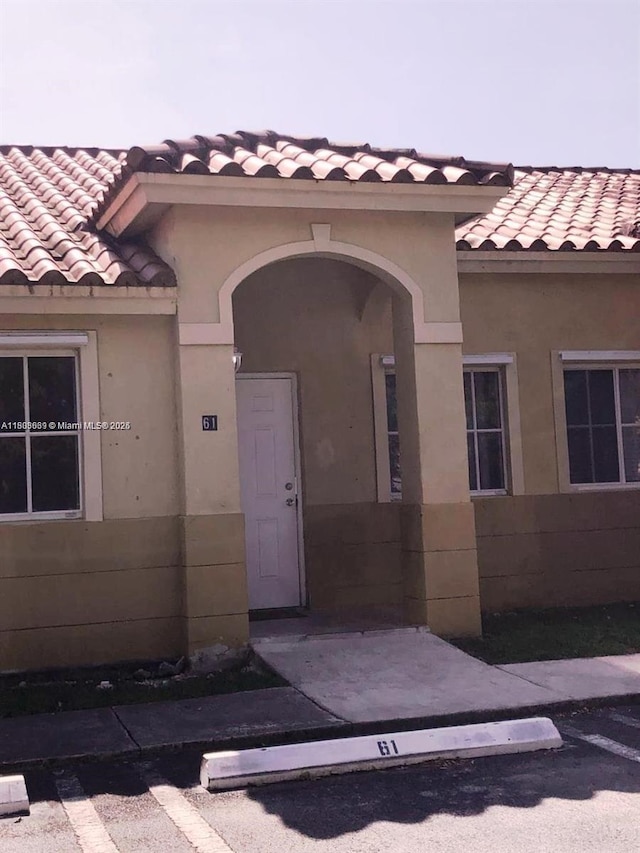 61 NE 13th Ave Unit 11, Homestead, FL 33033 - property entrance with a tiled roof and stucco siding