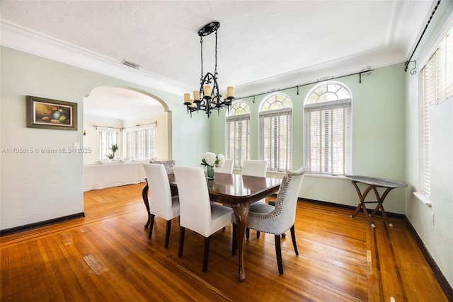 1801 SW 12th St, Miami, FL 33135 - dining area with arched walkways, healthy amount of natural light, a chandelier, hardwood / wood-style flooring, and crown molding