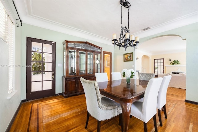 1801 SW 12th St, Miami, FL 33135 - dining room with arched walkways, wood finished floors, ornamental molding, and a chandelier