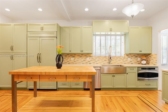 1801 SW 12th St, Miami, FL 33135 - kitchen with green cabinets, a sink, stainless steel appliances, decorative backsplash, and light wood-type flooring