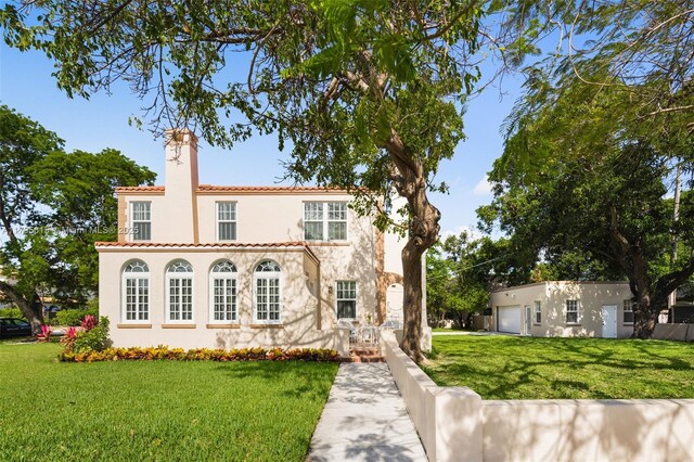 1801 SW 12th St, Miami, FL 33135 - mediterranean / spanish-style home featuring a chimney, a front lawn, stucco siding, a tiled roof, and a garage