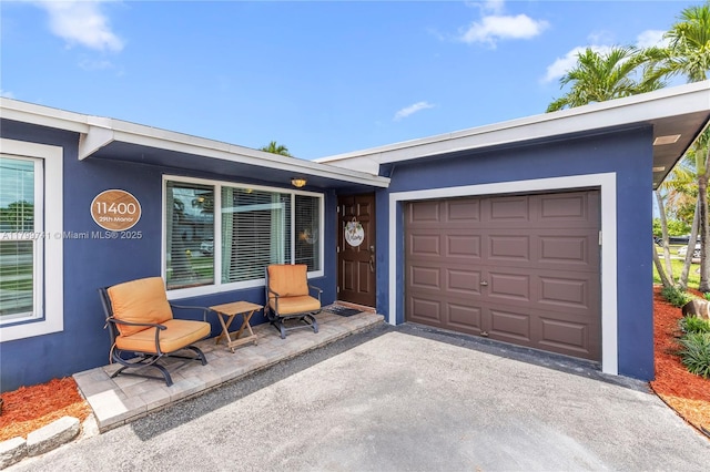 11400 NW 29th Mnr, Sunrise, FL 33323 - doorway to property featuring stucco siding, asphalt driveway, and a garage