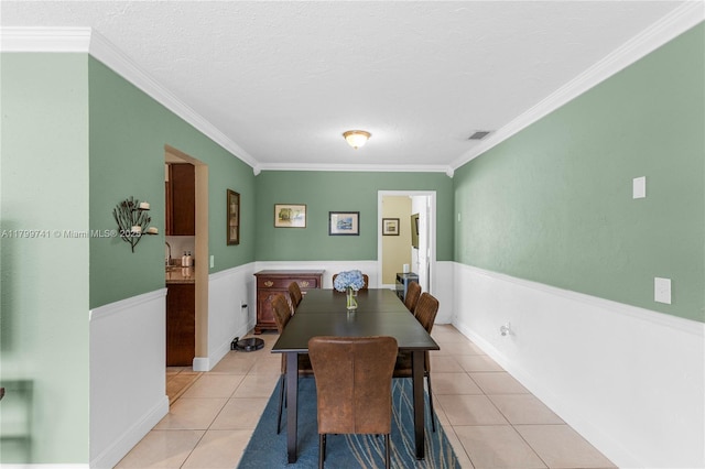 11400 NW 29th Mnr, Sunrise, FL 33323 - dining area featuring light tile patterned floors, ornamental molding, a textured ceiling, and a wainscoted wall