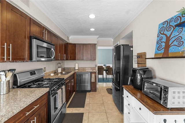 11400 NW 29th Mnr, Sunrise, FL 33323 - kitchen featuring stainless steel appliances, a sink, ornamental molding, light tile patterned floors, and a textured ceiling