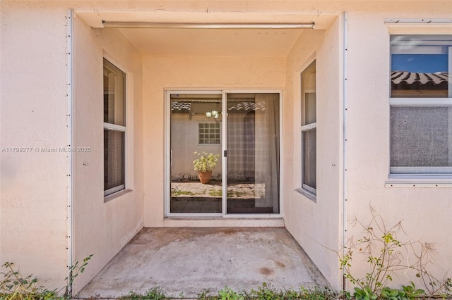 14202 SW 151st Ct, Miami, FL 33196 - view of exterior entry featuring stucco siding and a patio area