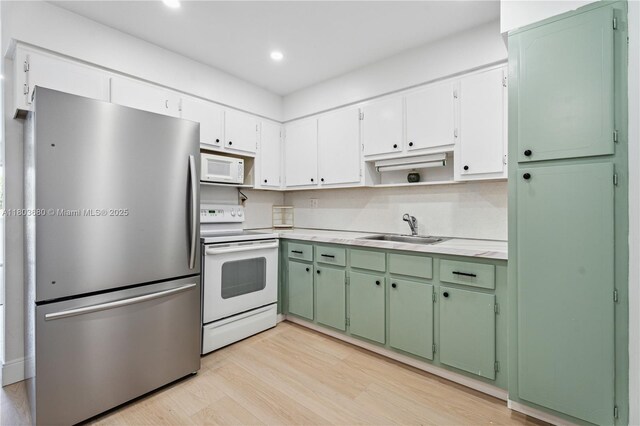 949 Pennsylvania Ave Unit 303, Miami Beach, FL 33139 - kitchen featuring white appliances, a sink, open shelves, light countertops, and light wood finished floors