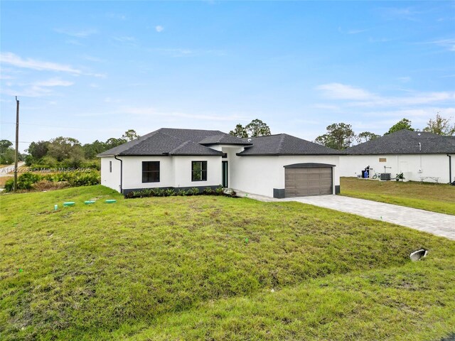 1222 Hibiscus, Lehigh Acres, FL 33972 - view of front of house with decorative driveway, an attached garage, stucco siding, a front lawn, and roof with shingles