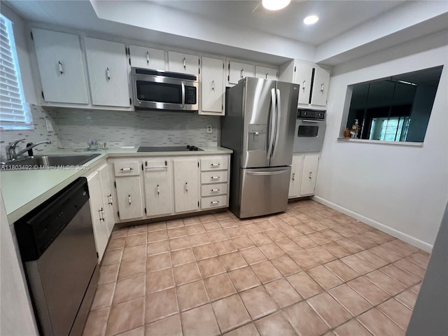 609 S State Road 7 Unit 2H, Margate, FL 33068 - kitchen featuring stainless steel appliances, a sink, light countertops, tasteful backsplash, and a tray ceiling