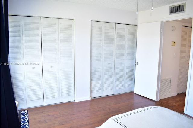 9121 Sunrise Lakes Blvd Unit 201, Sunrise, FL 33322 - unfurnished bedroom featuring hardwood / wood-style floors, two closets, and baseboards