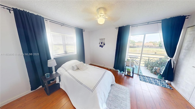 9121 Sunrise Lakes Blvd Unit 201, Sunrise, FL 33322 - bedroom featuring a textured ceiling, multiple windows, hardwood / wood-style floors, a ceiling fan, and baseboards