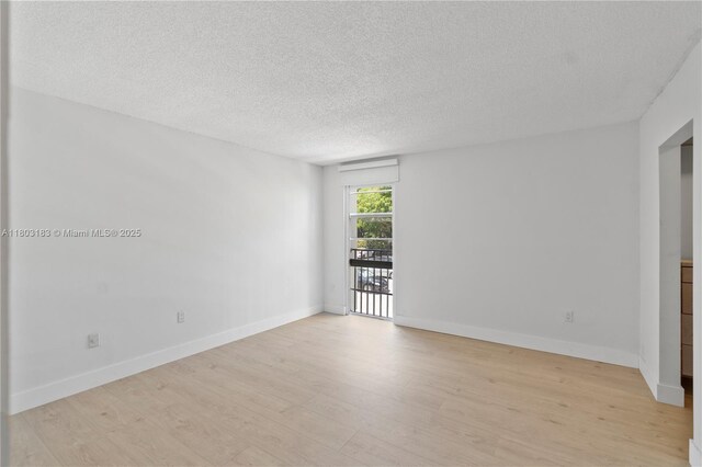 6886 N Kendall Dr Unit D207, Pinecrest, FL 33156 - empty room featuring light wood-style floors, a textured ceiling, and baseboards