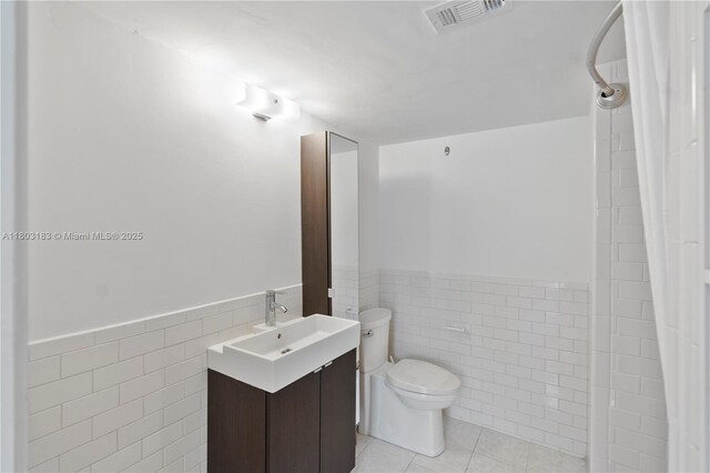 6886 N Kendall Dr Unit D207, Pinecrest, FL 33156 - full bathroom featuring tile walls, tile patterned floors, a wainscoted wall, toilet, and vanity
