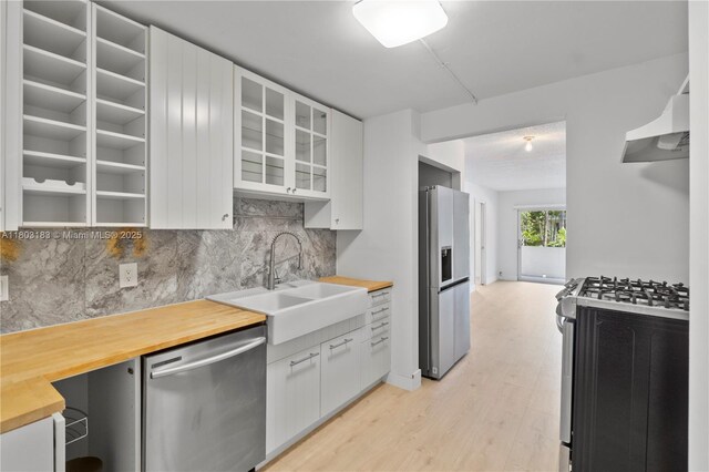 6886 N Kendall Dr Unit D207, Pinecrest, FL 33156 - kitchen with appliances with stainless steel finishes, butcher block counters, a sink, under cabinet range hood, and tasteful backsplash