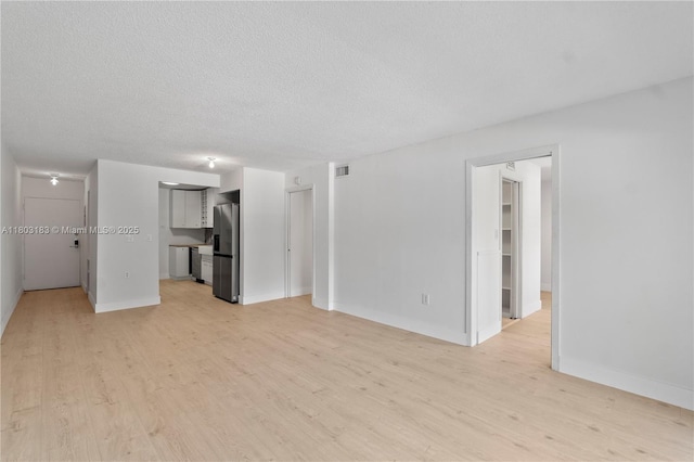 6886 N Kendall Dr Unit D207, Pinecrest, FL 33156 - unfurnished living room with light wood-style flooring, a textured ceiling, and baseboards