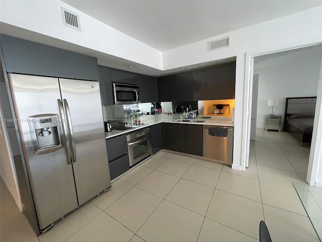 31 SE 6th St Unit 907, Miami, FL 33131 - kitchen featuring stainless steel appliances, light countertops, a sink, light tile patterned floors, and dark cabinetry