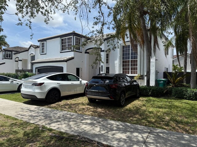 9740 SW 155th Ave, Miami, FL 33196 - view of front of home featuring stucco siding, a tiled roof, and an attached garage