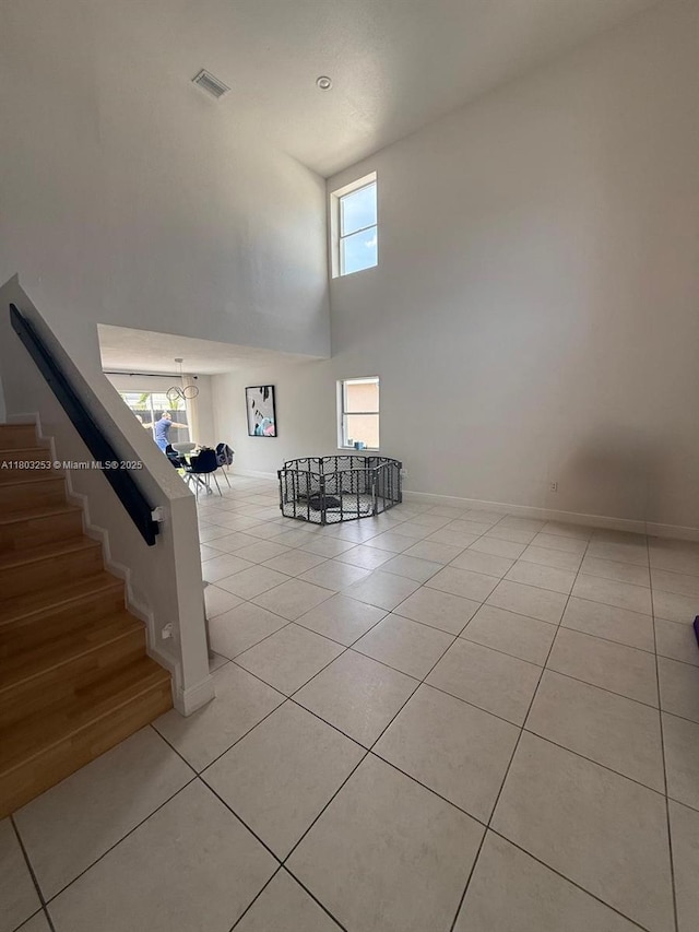 9740 SW 155th Ave, Miami, FL 33196 - unfurnished room featuring light tile patterned flooring, a towering ceiling, stairs, a chandelier, and baseboards