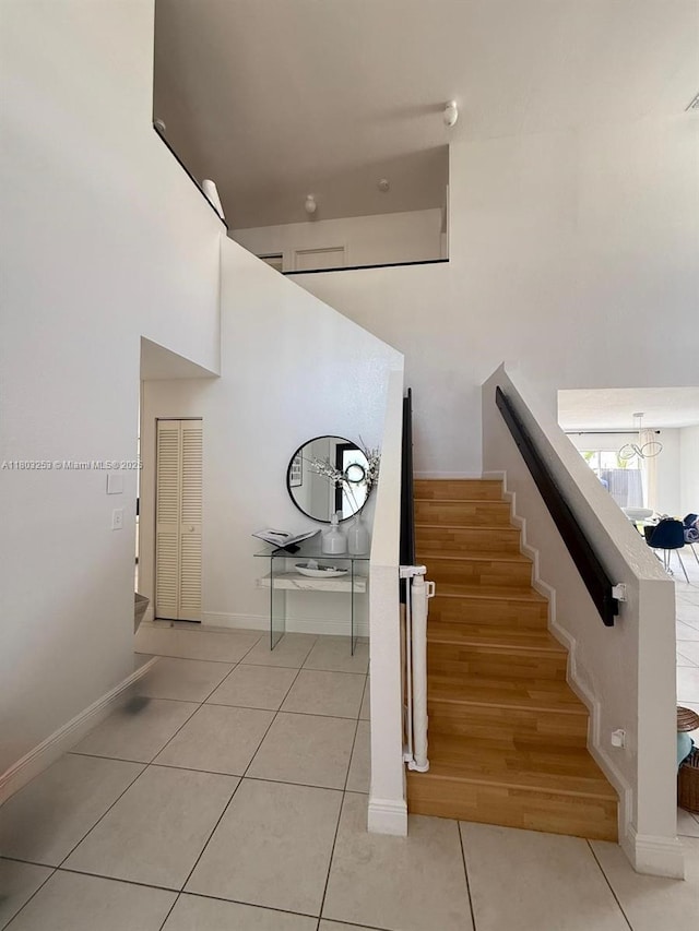 9740 SW 155th Ave, Miami, FL 33196 - staircase featuring tile patterned flooring, baseboards, and a towering ceiling