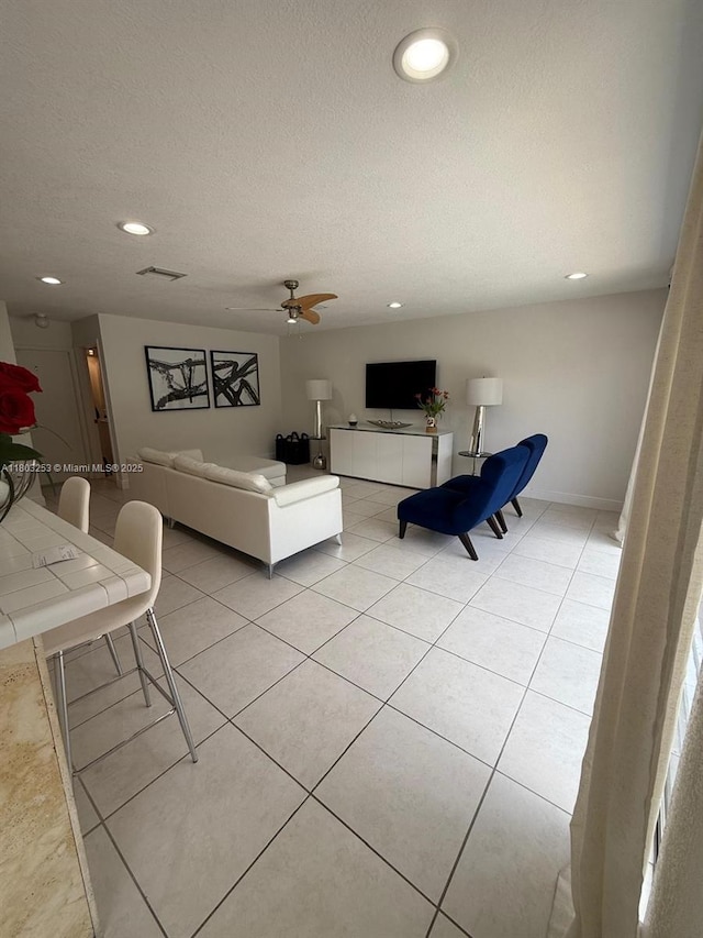 9740 SW 155th Ave, Miami, FL 33196 - living area featuring recessed lighting, a textured ceiling, a ceiling fan, light tile patterned flooring, and baseboards