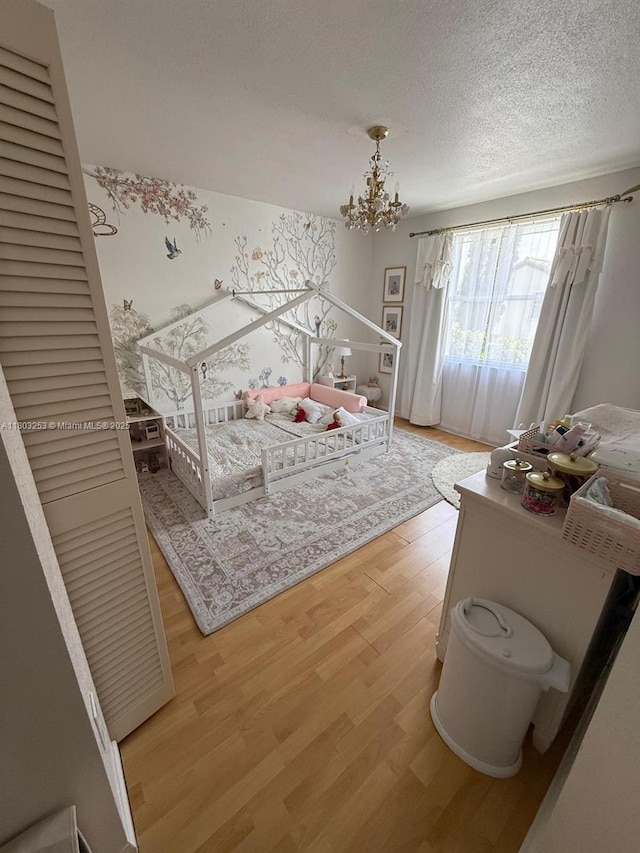 9740 SW 155th Ave, Miami, FL 33196 - bedroom featuring light wood-style flooring, a chandelier, and a textured ceiling
