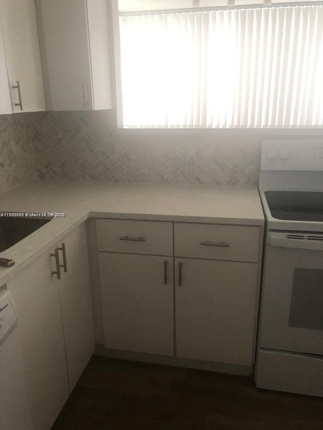250 180th Dr Unit 108, Sunny Isles Beach, FL 33160 - kitchen with white range with electric cooktop, white cabinetry, light countertops, and backsplash