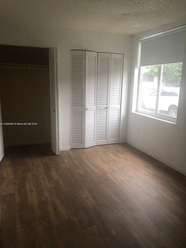 250 180th Dr Unit 108, Sunny Isles Beach, FL 33160 - unfurnished bedroom with wood finished floors and a textured ceiling