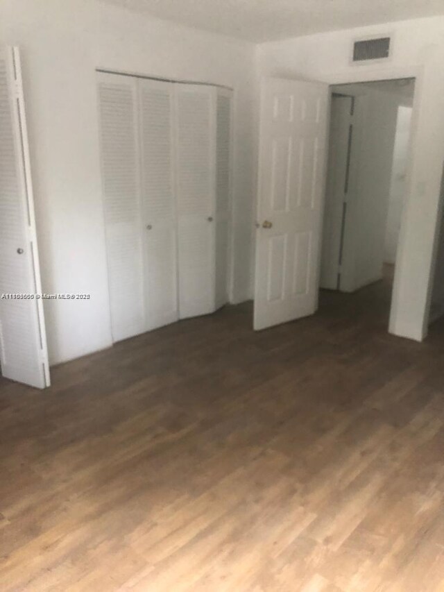 250 180th Dr Unit 108, Sunny Isles Beach, FL 33160 - unfurnished bedroom with a closet and wood finished floors